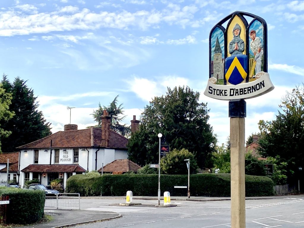 The Stoke D'Abernon village sign, with The Old Plough behind